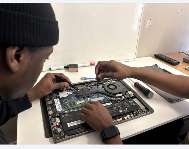 Simphiwe Madrati repairing a laptop motherboard
